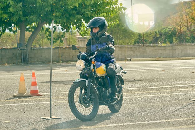 Motorcyclist riding modern motorcycle on motordrome AVB examen