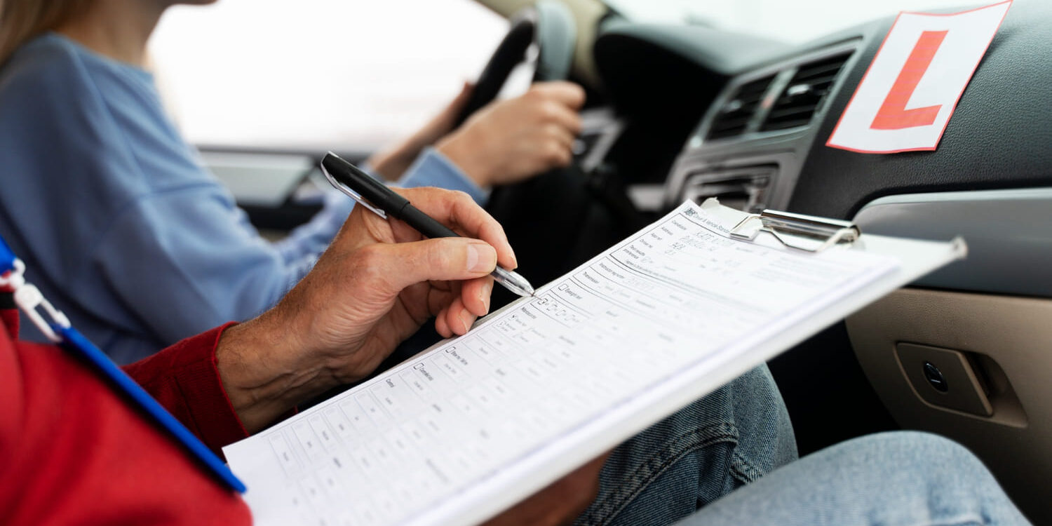 Auto les voorbereiding theorie Instructeur vult beoordelingsformulier in tijdens praktijkexamen voor autotheorie leren