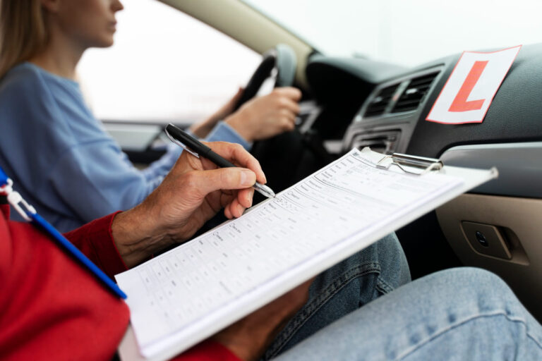 Instructeur vult beoordelingsformulier in tijdens praktijkexamen voor autotheorie leren