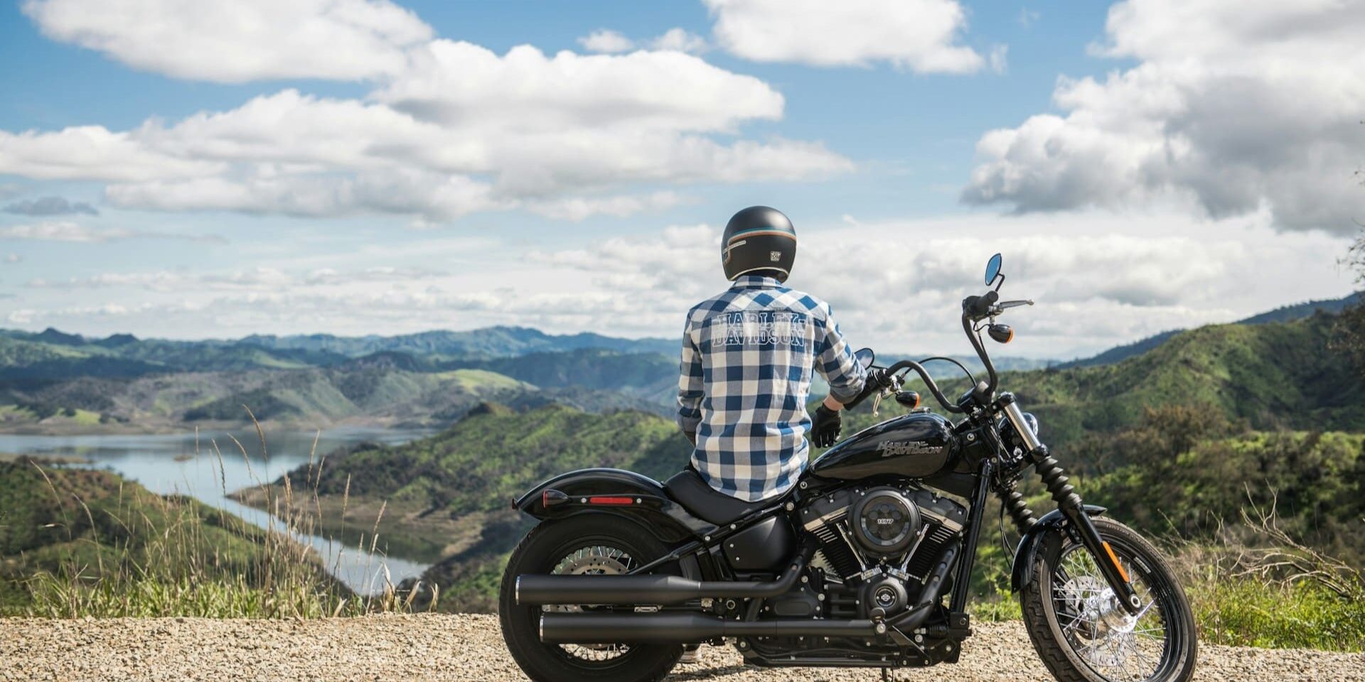 Motorrijder met uitzicht Motorrijder kijkt uit over berglandschap tijdens pauze – bewust veilig motorrijden