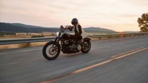 Motorrijder rijdt veilig over lege snelweg bij zonsondergang – veilig motorrijden in de